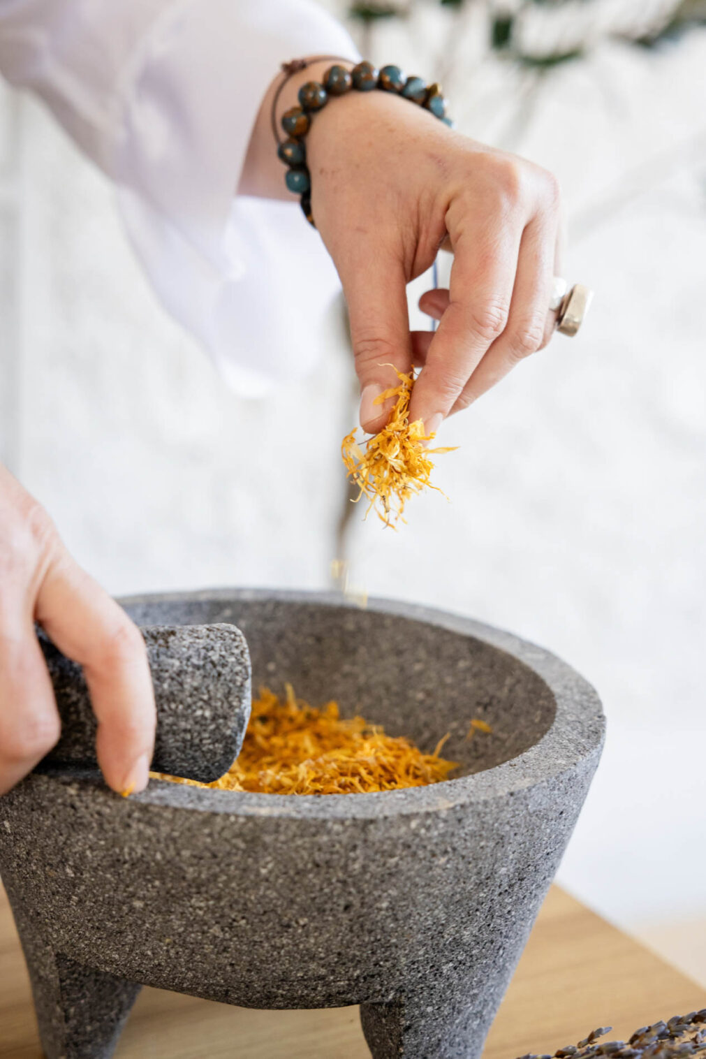 close up photo of a woman's hands mixing herbs