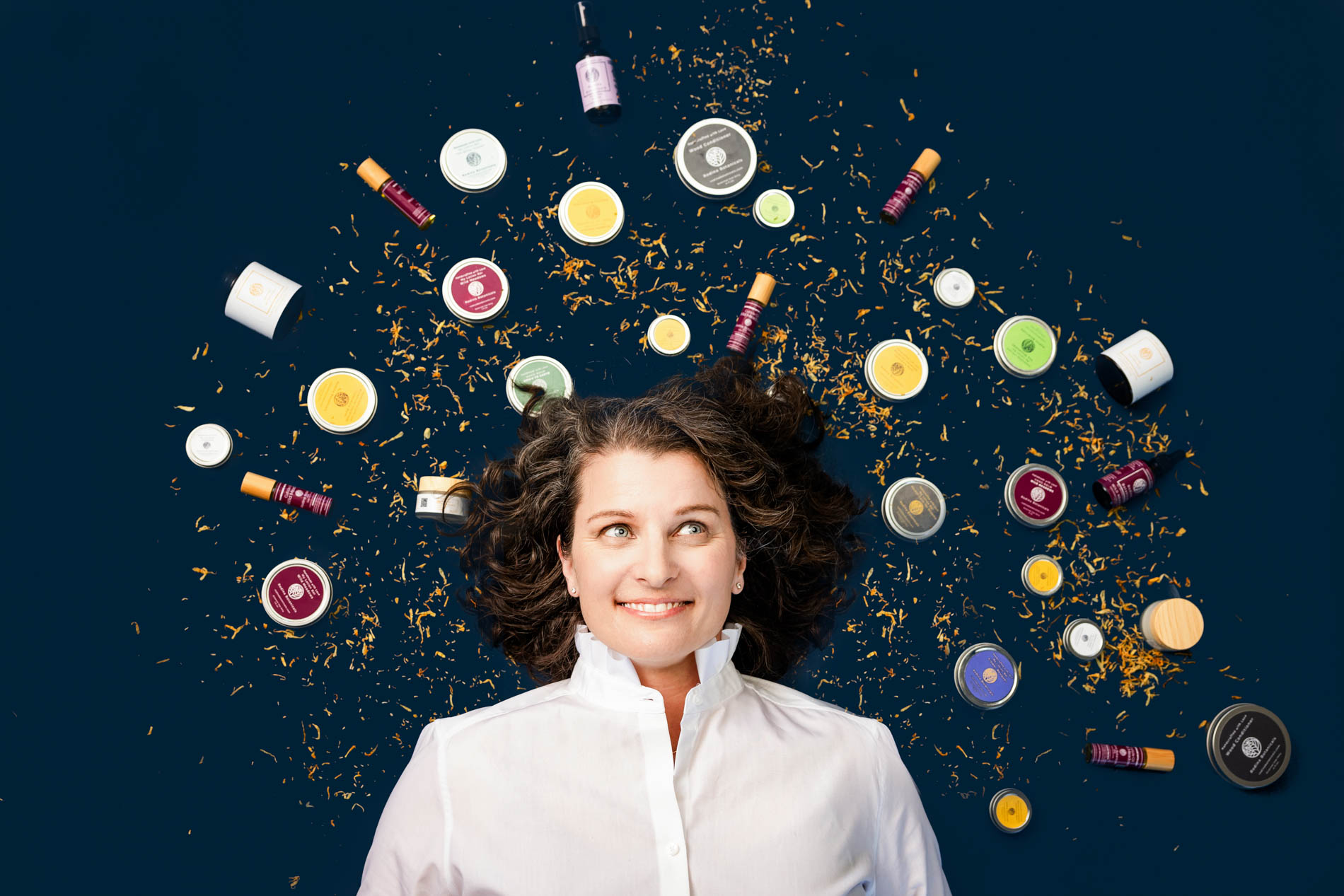 brand photo of woman surrounded by natural skin care products