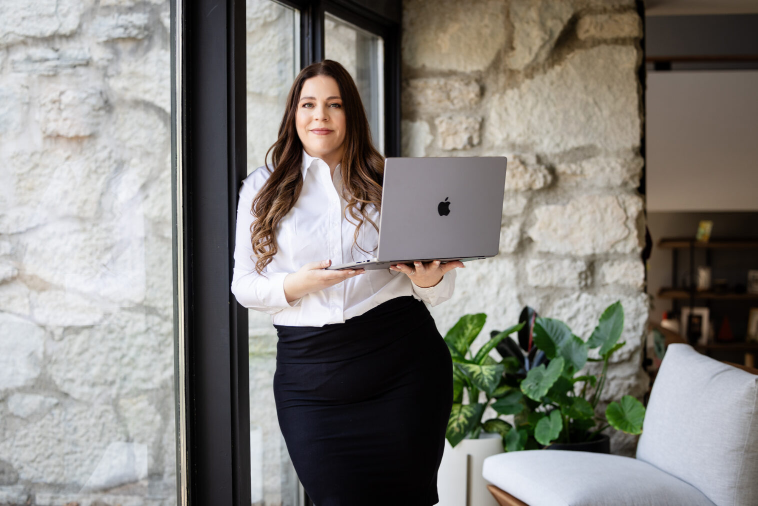 realtor lifestyle photo holding a laptop against fireplace