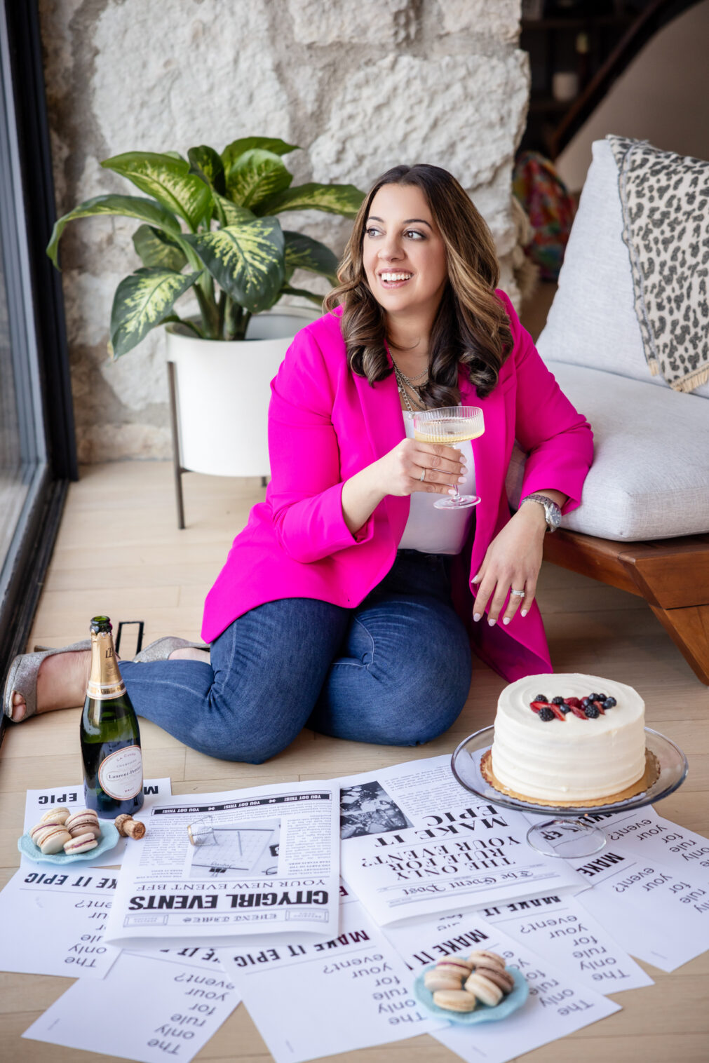 woman holds a champagne glass while looking out the window