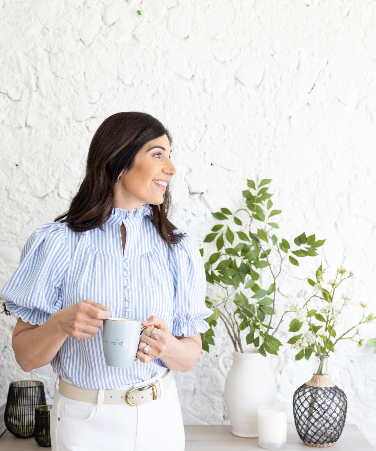 woman holding teacup looking away from camera and smiling