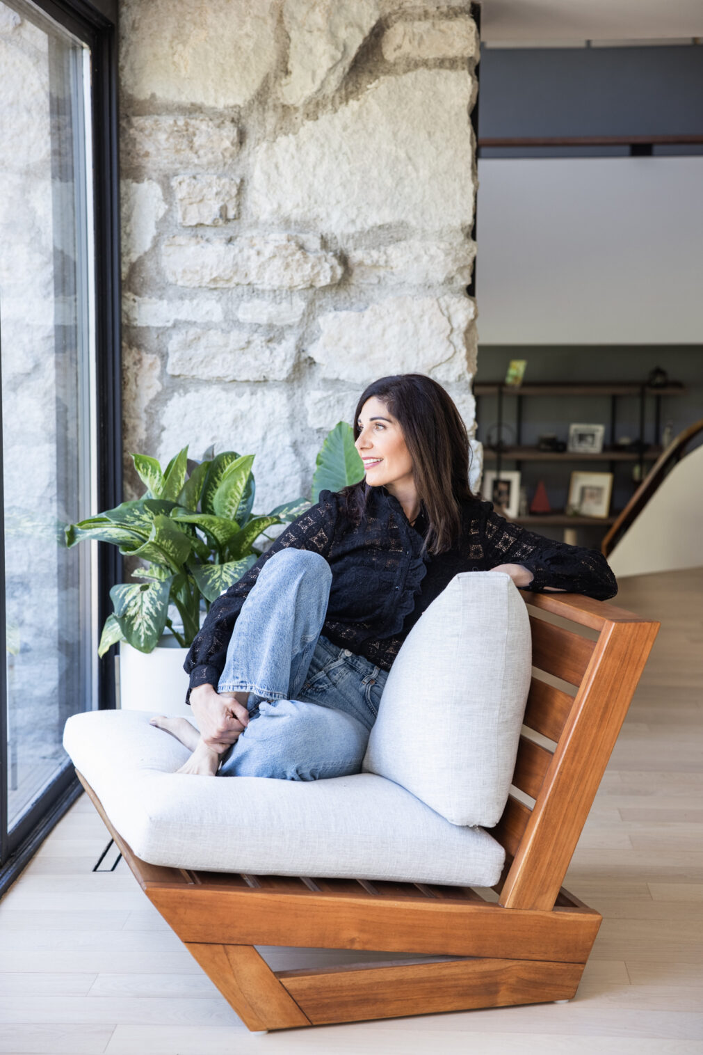woman sits on chair looking out of window