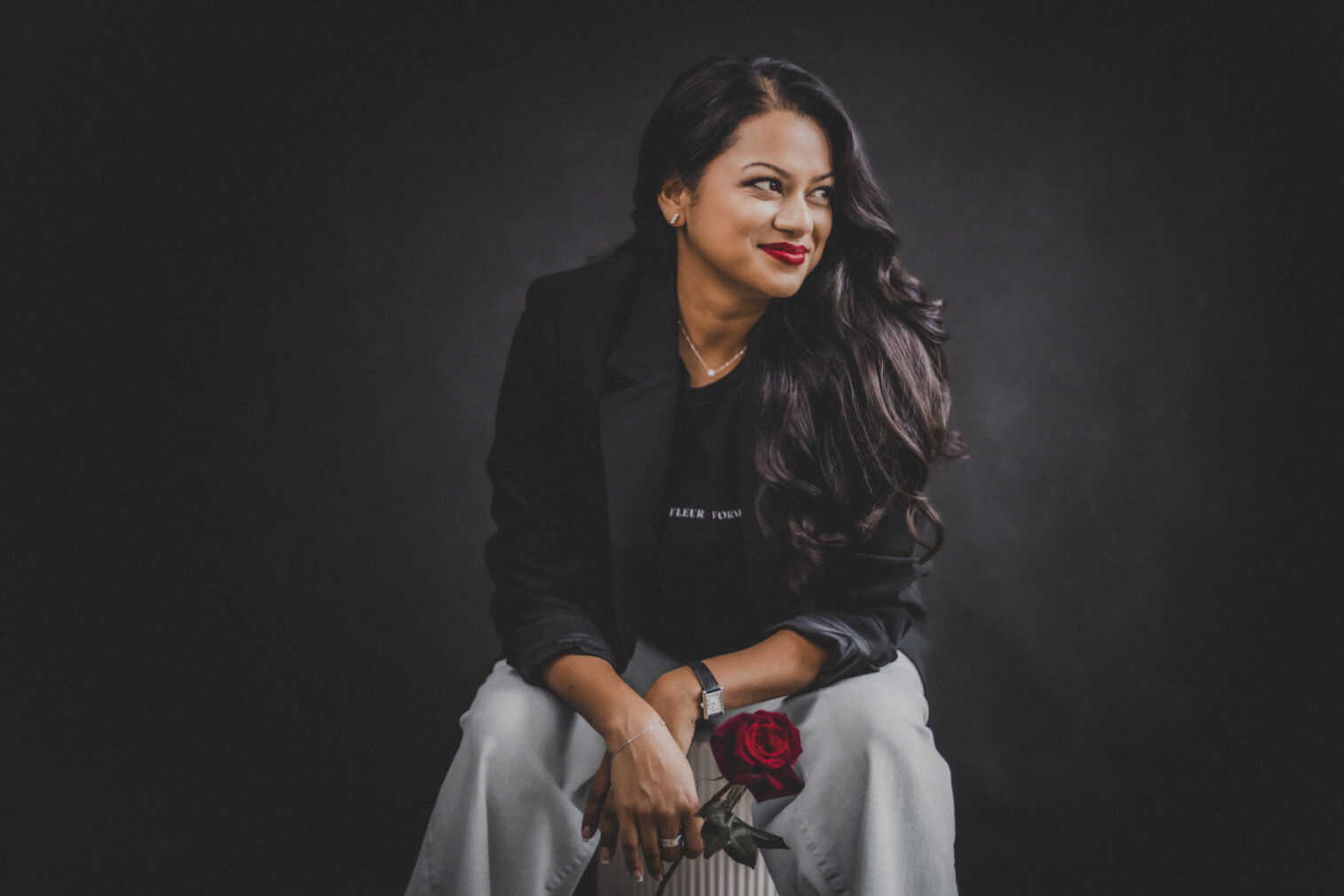 Moody branding image of a Barrington florist working in her studio with Valentine’s Day flowers and low light.
