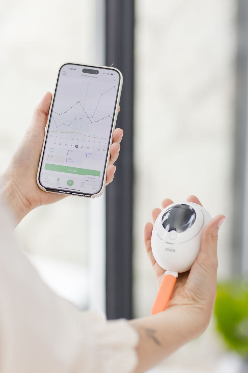 Close-up detail of Mira hormone tracking device used by wellness coach during branding session