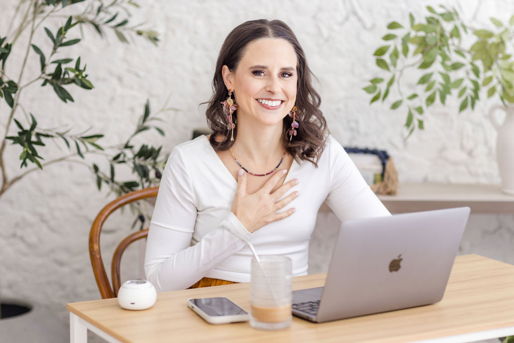 Wellness coach working on laptop during branding photoshoot in Chicago home studio